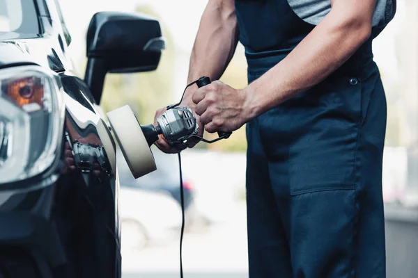 Partial view of car cleaner polishing car with buffer machine — Stock Photo