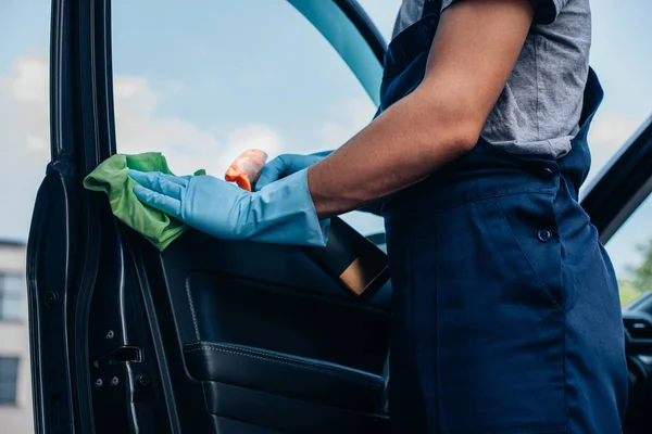 Vue recadrée du nettoyeur de voiture essuyant la porte de voiture avec chiffon — Photo de stock
