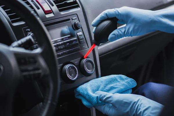 Cropped view of car cleaner dusting dashboard with rubber air cleaner — Stock Photo