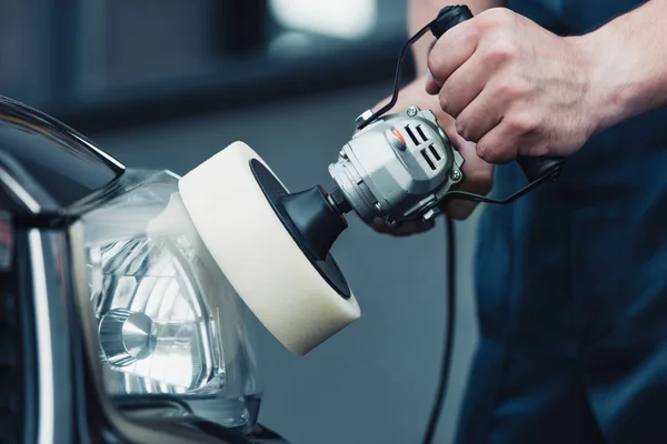 Partial view of car cleaner polishing headlamp with buffer machine — Stock Photo