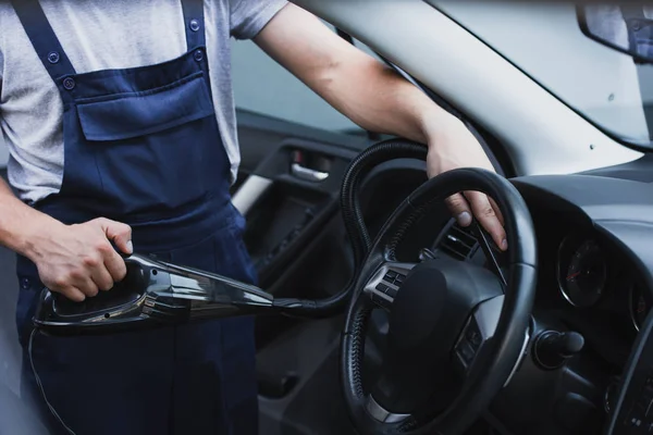 Cropped view of car cleaner vacuuming steering wheel — Stock Photo
