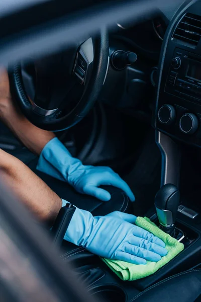 Cropped view of car cleaner wiping gear whifter with rag — Stock Photo