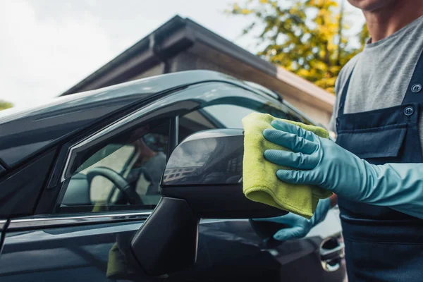 Ausgeschnittene Ansicht von Auto-Reiniger wischt Seitenspiegel mit Lappen ab — Stockfoto