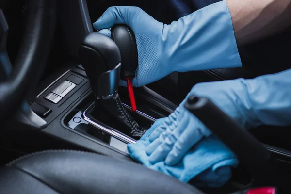Cropped view of car cleaner dusting gear shifter with rubber air lower and rag — Stock Photo