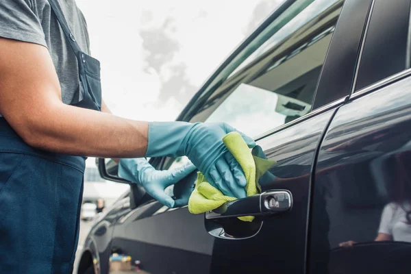 Ausgeschnittene Ansicht von Autoputzer wischt Autotür mit Lappen ab — Stockfoto