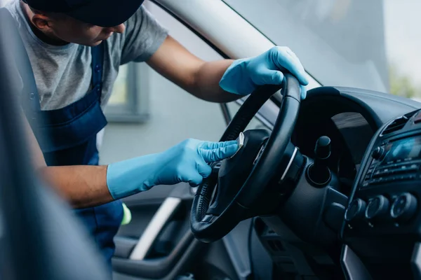 Enfoque selectivo del limpiador del coche limpiando el volante - foto de stock