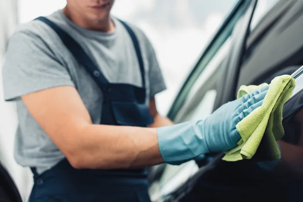 Cropped view of car cleaner wiping car with rag — Stock Photo