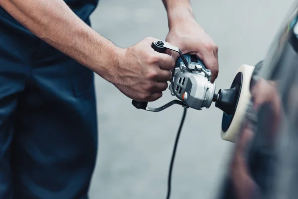 Partial view of car cleaner polishing car with buffer machine — Stock Photo