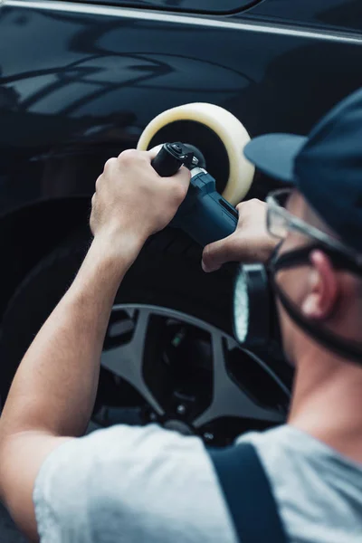 Selektiver Fokus des Autoreinigers in Schutzmaske Polierwagen mit Puffermaschine — Stockfoto