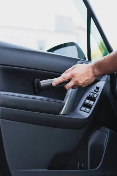 Partial view of car cleaner vacuuming car front door — Stock Photo