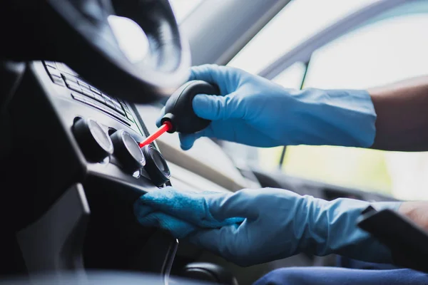 Cropped view of car cleaner dusting dashboard with rubber air blower — Stock Photo