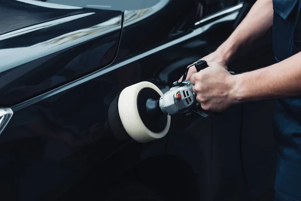 Vista recortada del coche limpiador pulido coche negro con la máquina tampón - foto de stock