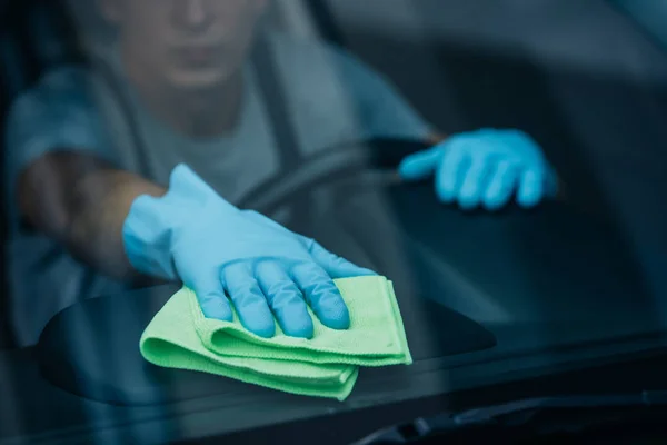 Selective focus of car cleaner wiping dashboard near windshield — Stock Photo