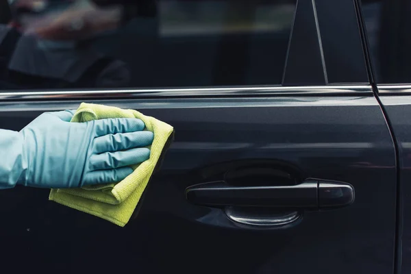 Vue recadrée du nettoyeur de voiture essuyant la porte de voiture avec chiffon — Photo de stock