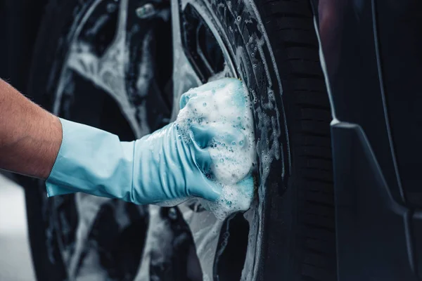 Vue partielle du nettoyeur de voiture essuyant roue avec chiffon — Photo de stock