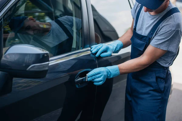 Ausgeschnittene Ansicht von Auto-Reiniger wischt Türgriff mit Lappen — Stockfoto