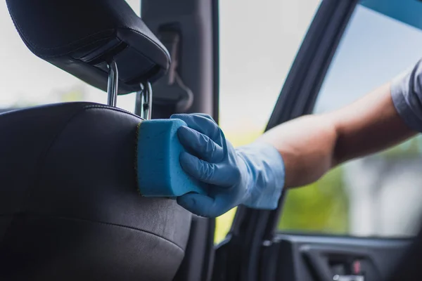 Vista parcial del limpiador de coches limpiando asiento de coche con esponja - foto de stock