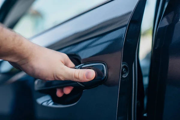 Vista recortada del hombre sosteniendo la manija de la puerta del coche - foto de stock