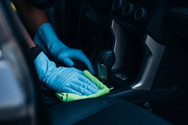 Cropped view of car dealer wiping gear shifter with rag — Stock Photo