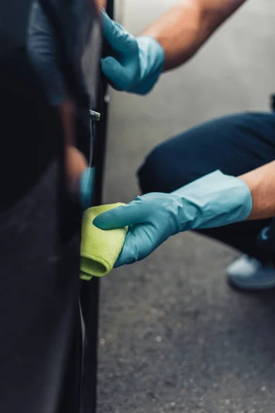 Обрізаний вид автомобіля чистіше протирання автомобільного колеса ганчіркою — стокове фото