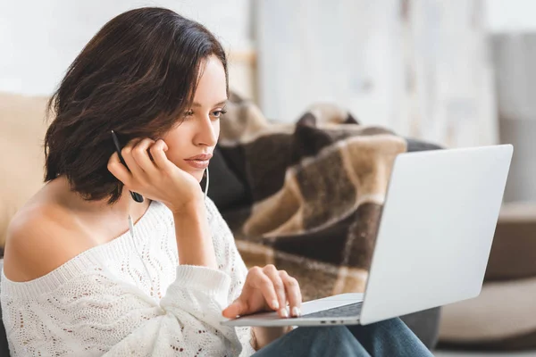 Красивая девушка учится онлайн с наушниками и ноутбуком — стоковое фото