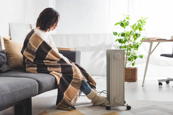 Schöne Frau mit Decke im Kühlraum mit Heizung — Stockfoto