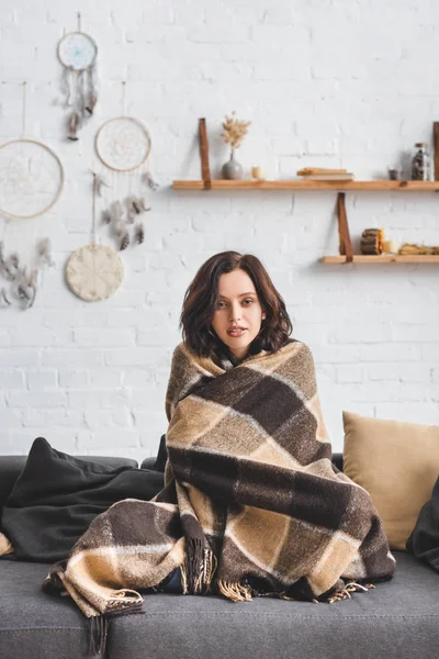 Schönes kaltes Mädchen wärmt sich mit Decke auf Sofa auf — Stockfoto