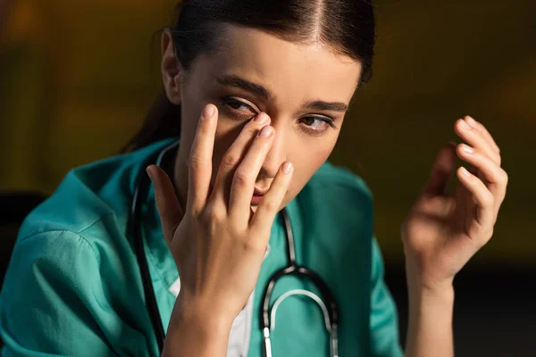 Infirmière attrayante et fatiguée en uniforme pleurant pendant le quart de nuit — Photo de stock