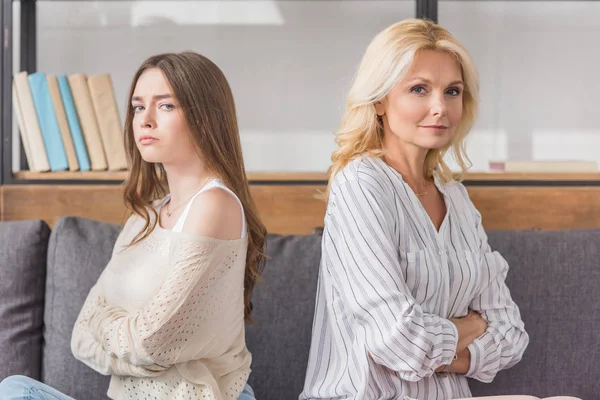 Offensé mère et fille assis dos à dos tout en regardant la caméra — Photo de stock