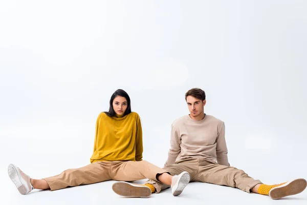 Guapo hombre y mujer sentado en blanco - foto de stock