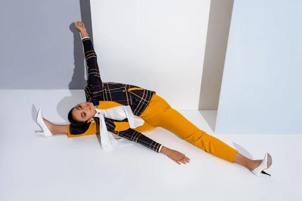 Attractive woman stretching on white and grey — Stock Photo