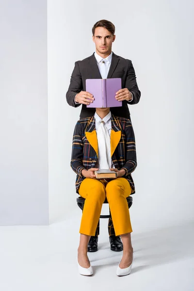 Homem elegante cobrindo rosto de mulher enquanto segurando livro em branco — Fotografia de Stock