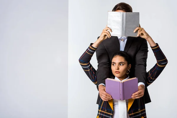 Attraktive Frau verdeckt Gesicht des Mannes, während sie Buch auf weiß hält — Stock Photo