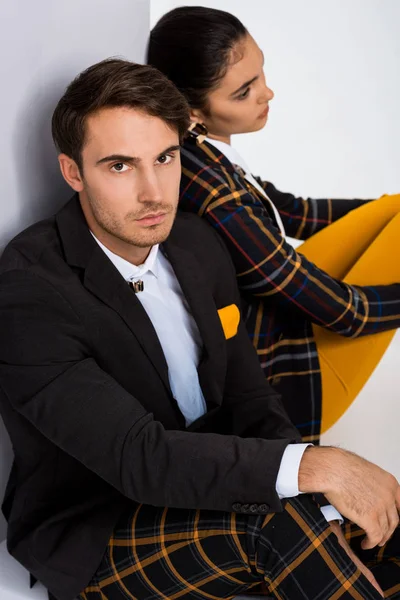 Selective focus of handsome man looking at camera near girl on white — Stock Photo