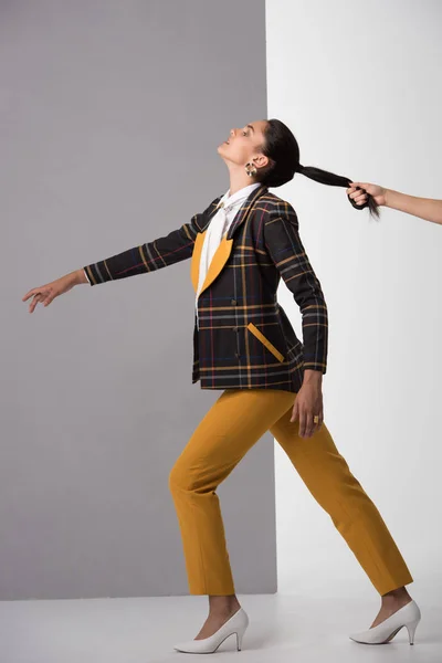 Recortado vista de hombre sosteniendo pelo de chica en blanco y gris - foto de stock