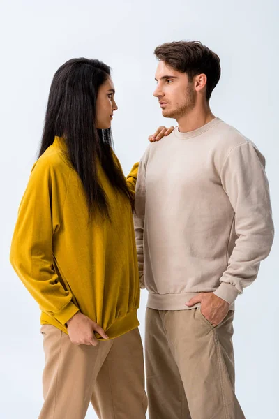 Menina atraente olhando para o homem com a mão no bolso isolado no branco — Fotografia de Stock