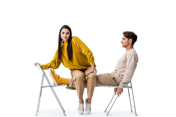 Beautiful girl sitting on chair near handsome man on white — Stock Photo