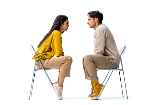 Side view of attractive woman sitting on chair and looking at man on white — Stock Photo