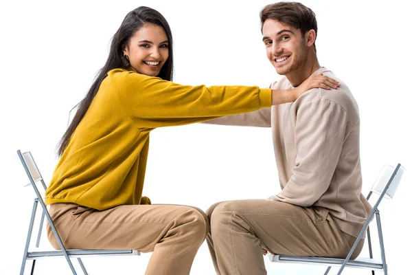 Glückliches Mädchen sitzt auf Stuhl und berührt Mann auf weiß — Stockfoto
