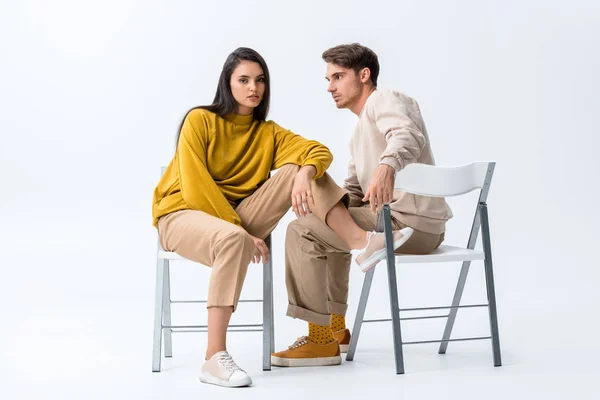 Bonito homem olhando elegante menina posando enquanto sentado no branco — Fotografia de Stock