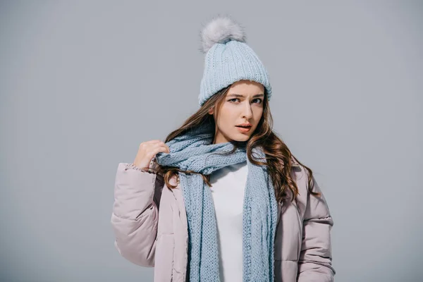 Стильна дівчина позує в теплому пальто, в'язаний капелюх і шарф, ізольована на сірому — стокове фото
