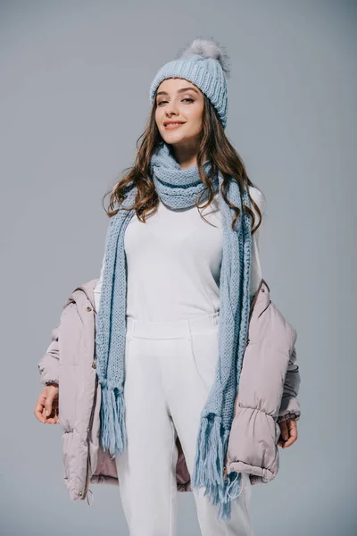 Attractive girl posing in warm coat, knitted hat and scarf, isolated on grey — Stock Photo