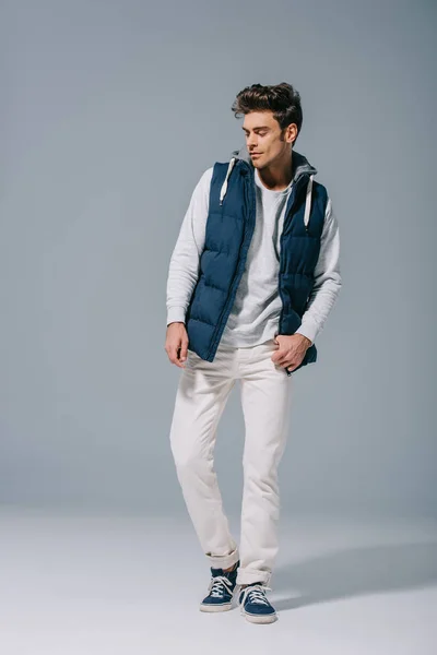 Bell'uomo alla moda in posa in autunno gilet su grigio — Foto stock