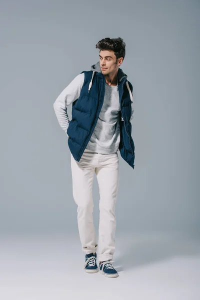 Handsome fashionable man posing in waistcoat on grey — Stock Photo