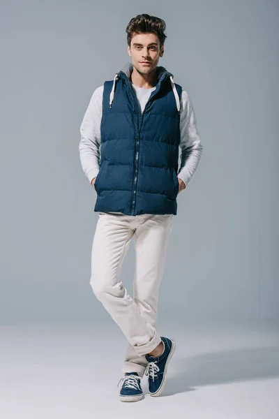 Handsome fashionable man posing in waistcoat on grey — Stock Photo