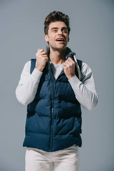 Bonito sorridente homem posando no outono colete, isolado no cinza — Fotografia de Stock