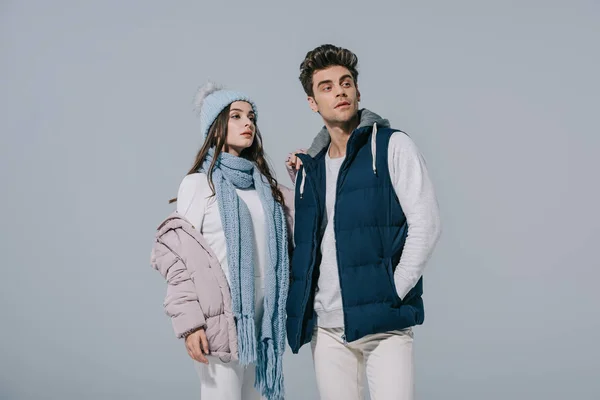 Beau couple élégant posant en tenue d'hiver, isolé sur gris — Photo de stock