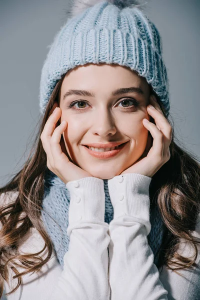 Smiling woman posing in knitted hat and scarf, isolated on grey — Stock Photo