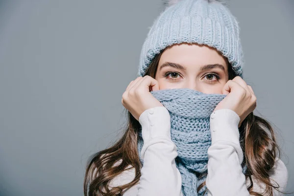 Attractive woman posing in knitted hat and scarf, isolated on grey — Stock Photo
