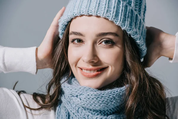 Hermosa mujer sonriente posando en sombrero de punto y bufanda, aislado en gris - foto de stock